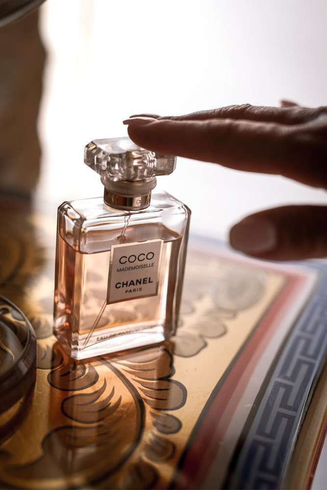 main de la mariée délicatement posée sur un flacon de parfum Chanel