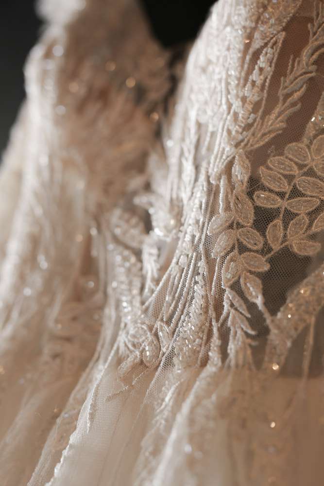 détail de la robe de mariée avec de la dentelle et des perles