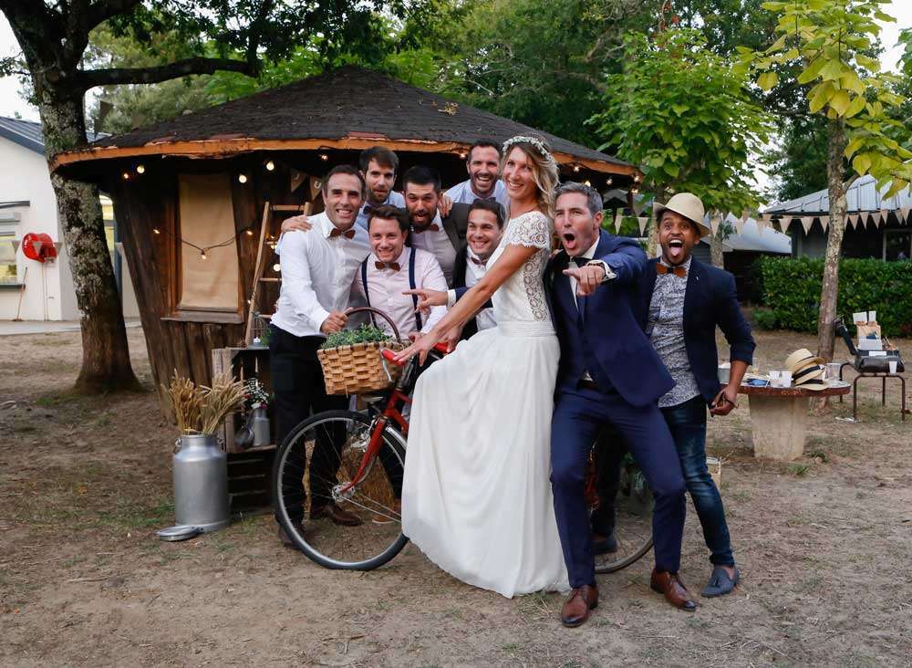 les mariés et témoins posent pour la photo, la mariée est assise sur le vélo de décoration