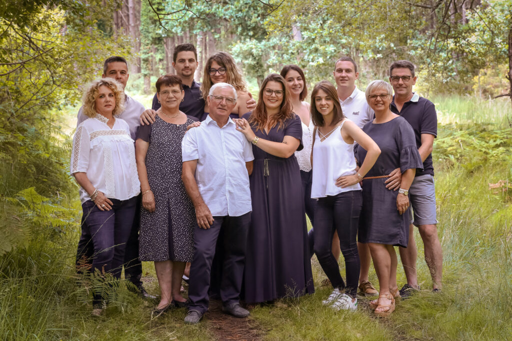 portrait de famille composée de 12 personnes de la même famille en forêt sous les pins